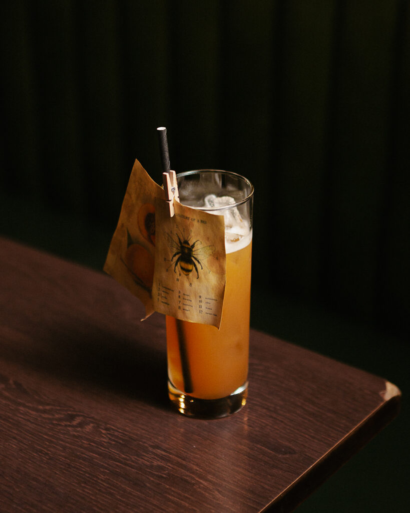 a glass of liquid with a paper and a straw on a table
